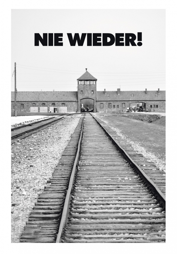 El cartel del homenaje con la foto de la entrada al campo de exterminio de Auschwitz