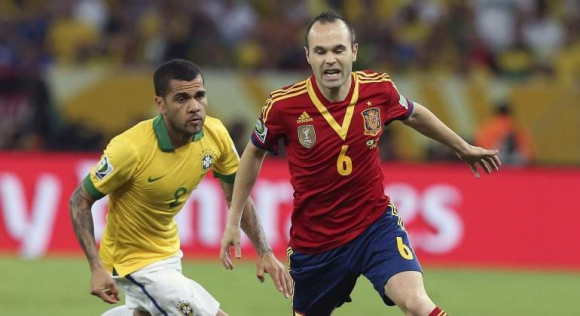 Iniesta y Alves en un España-Brasil