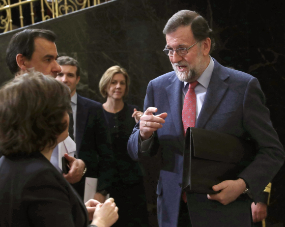 Cospedal observa a Soraya mientras esta charla con Rajoy