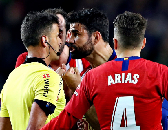 El delantero hispano-brasileño del Atlético de Madrid, Diego Costa (2d), protesta una jugada al colegiado Gil Manzano, acción que le ha costado la expulsión (EFE/Alberto Estévez).