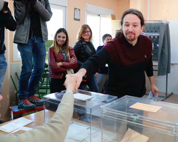 El líder de Podemos, Pablo Iglesias, saluda a los integrantes de la mesa electoral en el colegio Público de La Navata donde votó hoy./EFE/Angel Díaz