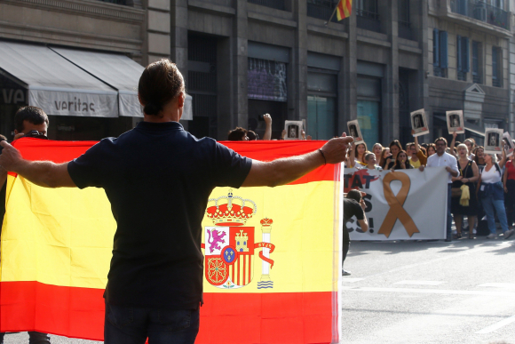 Un hombre con una bandera de España se encara con los centenares de personas que cortan la céntrica Via Laietana de Barcelona en protesta por la sentencia del procés