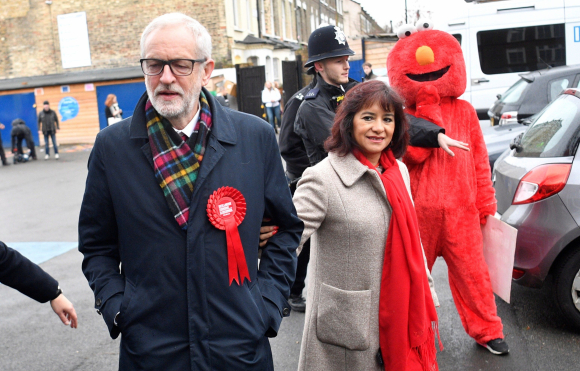Jeremy Corbyn y su mujer Laura Alvez junto a un manifestante disfrazado de Elmo. / EFE