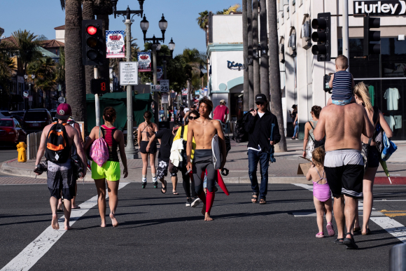 Imagen de una calle llena de gente en la playa de Huntington, en California