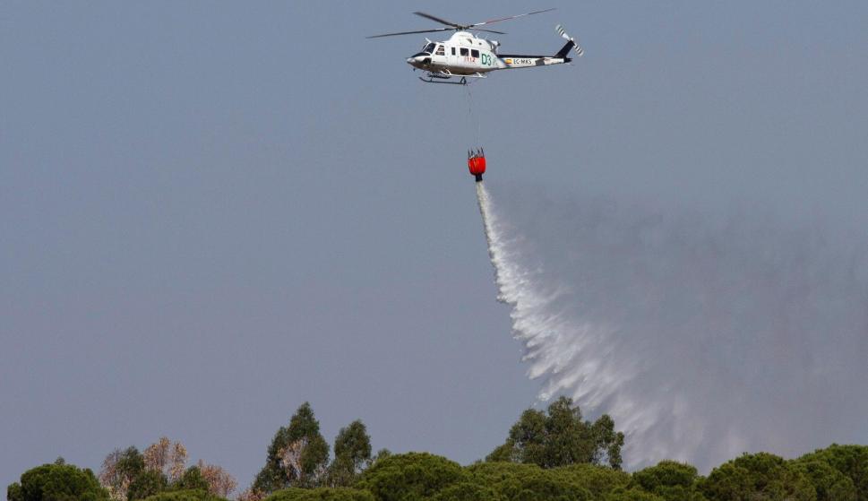 Un helicóptero de extinción de incendios trabaja en el Paraje de Fuente de la Corcha, en el término municipal de Beas (Huelva). /EFE