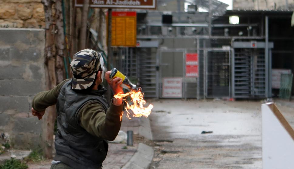 Un palestino lanza un cóctel molotov contra soldados israelíes durante enfrentamientos en Hebron, Palestina, hoy, 30 de marzo de 2018. EFE/ Abed Al Hashlamoun