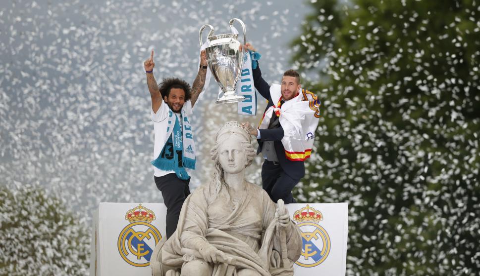 El defensa y capitán del Real Madrid, Sergio Ramos (d), alza la copa en la plaza de Cibeles, junto a su compañero el brasileño Marcelo, (EFE/ Javier Lizón)