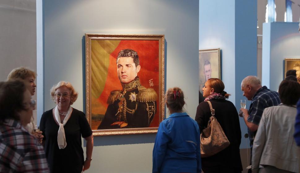 Los visitantes miran el retrato del futbolista portugués Cristiano Ronaldo del artista italiano Fabrizio Birimbelli en el Museo de la Academia Rusa de las Artes (EFE / EPA / ANATOLY MALTSEV)