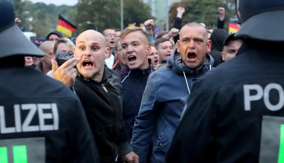 Manifestantes de ultraderecha gritan detrás de una fila de policías en Chemnitz, Alemania, el 1 de septiembre de 2018. (EFE / EPA / MARTIN DIVISEK)