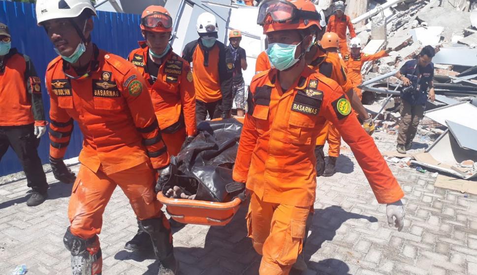 Imagen facilitada por la Agencia Nacional de Búsqueda y Rescate de Indonesia que muestra a los rescatistas llevando los cuerpos de las víctimas del terremoto y tsunami en Palu. (EFE)