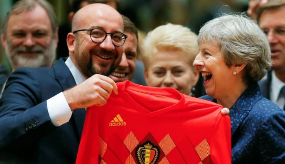 El primer ministro belga, Charles Michel, regala una camiseta de la selección belga de fútbol a la primera ministra británica Theresa May, durante la reunión del Consejo Europeo celebrada en Bruselas, Bélgica, el 28 de junio del 2018. EFE