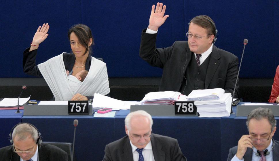 La eurodiputada Licia Ronzulli (i) sostiene a su bebé dormido en brazos mientras vota durante la sesión plenaria mensual del Parlamento Europeo en 2010. (EFE)