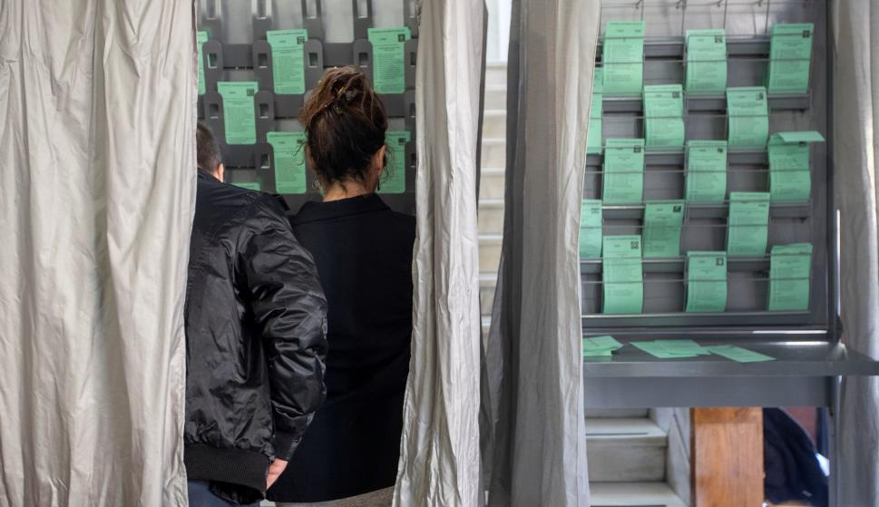 Una pareja escoge la papeleta en el colegio electoral ubicado en la biblioteca de Sanlúcar de Barrameda (Cádiz). EFE/Jose Manuel Vidal.