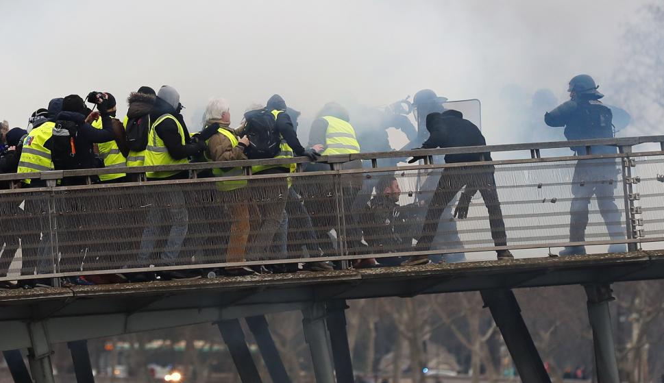 La policía antidisturbios se enfrenta a los manifestantes cuando intentan cruzar el río Sena durante la protesta de 'chalecos Amarillos' en París, el 5 de enero de 2019. (EFE/EPA/IAN LANGSDON)