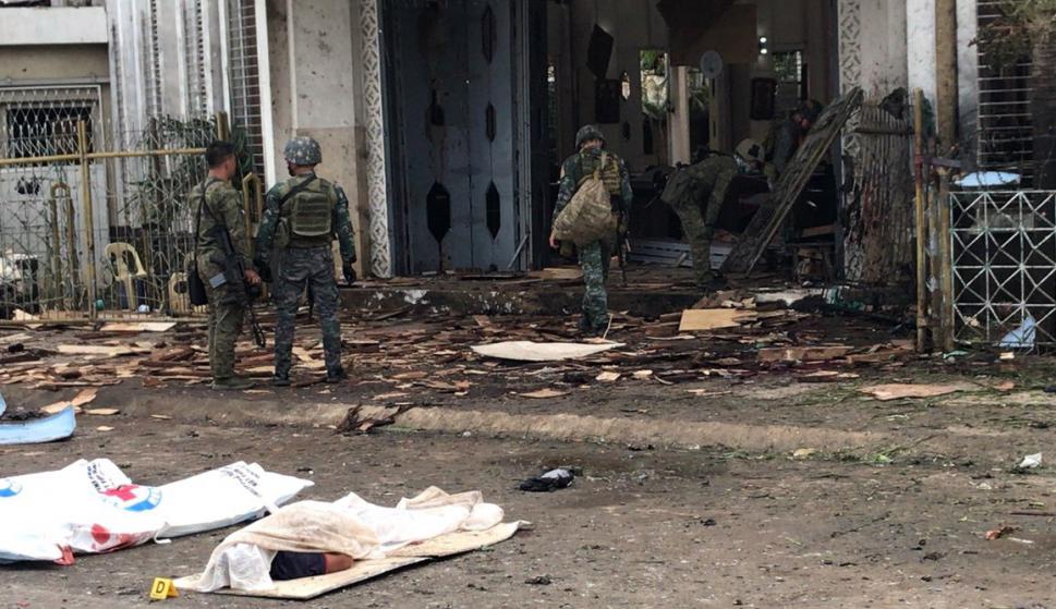 Soldados filipinos reúnen evidencias junto a los cuerpos cubiertos de víctimas frente a una iglesia tras las explosiones en la ciudad de Jolo, Sulu, Filipinas, el 27 de enero. (EFE/EPA/PEEWEE BACUNO)
