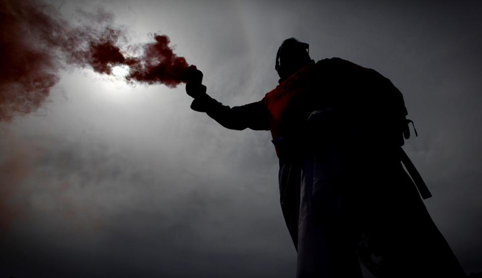 Un trabajador de Alcoa con un bote de humo en la cabecera de la manifestación de A Coruña. /EFE/Cabalar