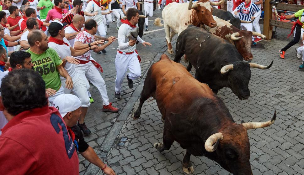 Los toros de la ganadería de La Palmosilla, de Tarifa (Cádiz), a su paso por el tramo de Telefónica, durante el séptimo encierro de los Sanfermines 2019. /EFE/Daniel Fernández