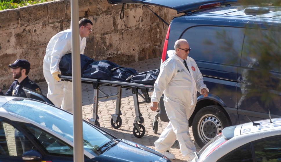 Personal de los servicios funerarios retiran el cuerpo sin vida de la mujer fallecida en Palma. /EFE