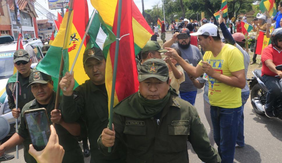 Un grupo de policías ondea la bandera tricolor de Bolivia mientras se repliega a una comisaría este sábado en la ciudad de Santa Cruz. /EFE/Juan Carlos Torrejón