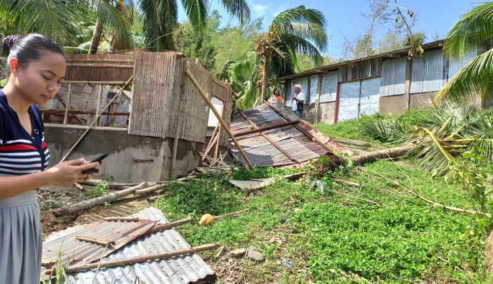 Una vecina al lado de una casa dañada en la ciudad de Balasan, provincia de Ilo-Ilo, afectada por el tifón. /EFE