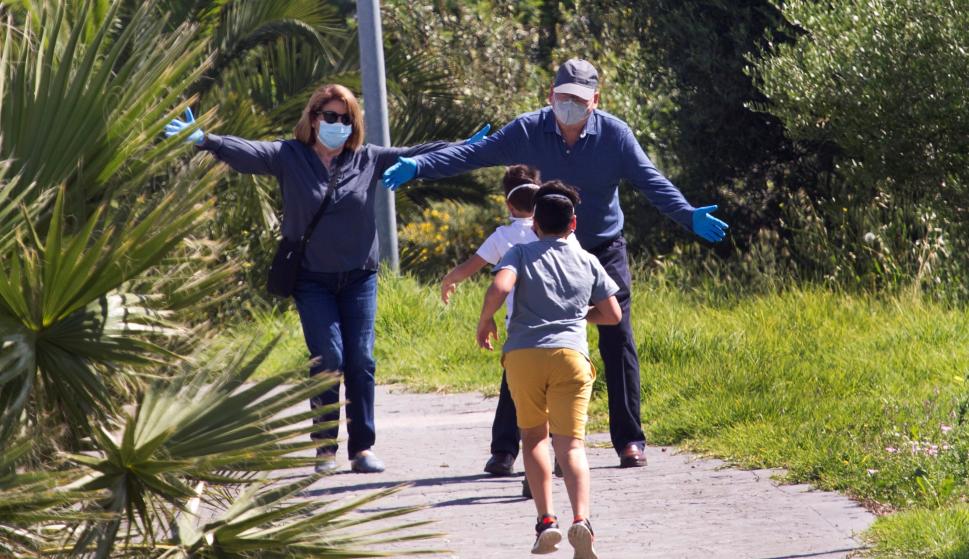 Dos niños corren a los brazos de sus abuelos, a los que no han visto en los últimos dos meses, en la urbanización de la Ermita en Algeciras, Cádiz, este sábado. EFE/ A.carrasco Ragel