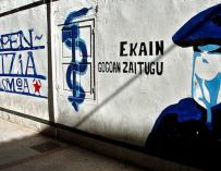 Mural que representa a un encapuchado junto al anagrama de ETA