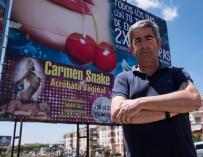 El portavoz de Izquierda Unida en el Ayuntamiento de Lepe (Huelva), Carmelo Cumbreras, posa delante del cartel publicitario.