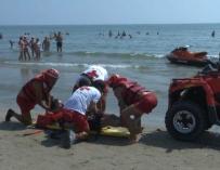 Fotografía de miembros de Cruz Roja atendiendo a un bañista.