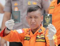 Un rescatista muestra los pasaportes de dos pasajeros del accidente aéreo de este lunes en el puerto de Tanjung Priok