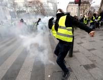 Un manifestante de los chalecos amarillos lanza un objeto a las fuerzas policiales durante una manifestación cerca de los Campos Elíseos en París, Francia, el 8 de diciembre de 2018. (EFE/EPA/IAN LANGSDON)