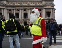 Un manifestante "chaleco amarillo" que viste un traje de Papá Noel asiste a una manifestación frente a la Ópera en París, Francia, el 15 de diciembre de 2018. (EFE/EPA/IAN LANGSDON)