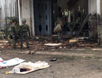 Soldados filipinos reúnen evidencias junto a los cuerpos cubiertos de víctimas frente a una iglesia tras las explosiones en la ciudad de Jolo, Sulu, Filipinas, el 27 de enero. (EFE/EPA/PEEWEE BACUNO)