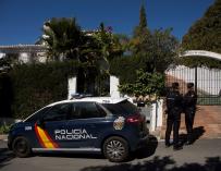 Dos miembros de la Policía Nacional custodian la vivienda donde anoche una mujer de 58 años y nacionalidad española fue asesinada tras ser apuñalada, en presencia de su hijo menor, en Estepona (Málaga) EFE/Daniel Pérez