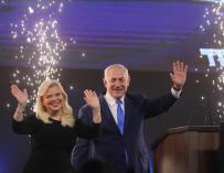 El primer ministro de Israel y jefe del partido Likud, Benjamin Netanyahu, celebra con su esposa Sara poco después de que fueran presentadas las previsiones televisivas de las elecciones generales que anuncian un empate entre Netanyahu y Benny Gantz, del