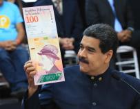 Nicolás Maduro muestra una imagen de un billete de 100 bolívares en una rueda de prensa