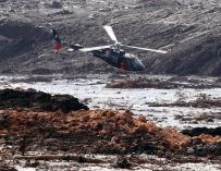 Un helicóptero busca supervivientes tras el desastre causado por la rotura de una represa que contenía residuos minerales en Brumadinho, Brasil ( EFE/ Paulo Fonseca)
