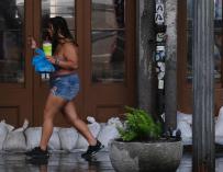 Una mujer camina por una tienda del Barrio Francés rodeada de bolsas de arena cuando se acerca la tormenta tropical Barry a Nueva Orleans, Louisiana. /EFE
