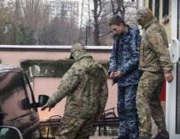 Miembros de los Servicios de Seguridad de Rusia escoltan a un marinero ucraniano detenido desde el tribunal de Simferópol, en Crimea. (Foto: EFE)