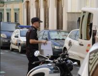 Un policía saca una caja del edificio del centro de Las Palmas de Gran Canaria donde este lunes un hombre ha matado a su expareja