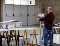 Un funcionario colocan la identificación de una mesa en un colegio electoral de Vitoria, minutos antes de constituirse las mesas