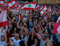 Los manifestantes agitan banderas libanesas y gritan consignas antigubernamentales durante una protesta frente al palacio de gobierno en el centro de Beirut. /EFE