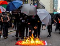 Manifestantes queman una bandera conmemorativa del Día Nacional en Hong Kong