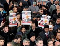 Hombres sostienen una imágenes del periodista opositor saudí Jamal Khashoggi mientras rezan en la mezquita Fatih, en Estambul (Turquía)
