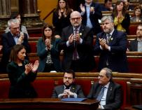 El presidente de la Generalitat, Quim Torra (d), es aplaudido por los miembros de su partido mientras que su vicepresidente, Pere Aragonés (i), y los diputados de ERC permanecen sentados. /EFE