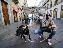 Un hombre con una máscara para protegerse contra el COVID-19 pasea a su perro en Turín, Italia, el 26 de febrero de 2020. /EFE / EPA / Tino Romano