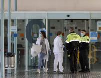 Dos agentes de seguridad junto a dos enfermeras en la entrada principal del Hospital del Mar de Barcelona.
