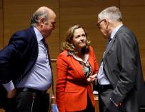 La ministra de Economía, Nadia Calviño (c), conversa con el vicepresidente del Banco Central Europeo, Luis de Guindos (i), y el director gerente del Mecanismo Europeo de Estabilidad, Klaus Regling (d), antes del comienzo del Consejo de Ministros