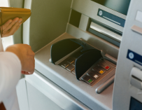 Fotografía de un persona sacando dinero del cajero. Algunos bancos en España permiten cobrar la pensión antes a los jubilados por le coronavirus.