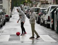niño en la calle jugando a la pelota coronavirus
