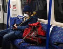 Un hombre con una máscara utiliza el metro de Londres el 14 de abril de 2020. /EFE/EPA/NEIL HALL